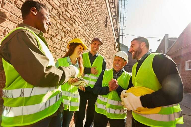 Groupe de référents en gilet de sécurité échangeant sur les bonnes pratiques