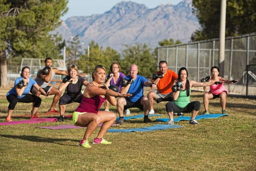 Groupe de salariés pendant une séance de cross training en extérieur