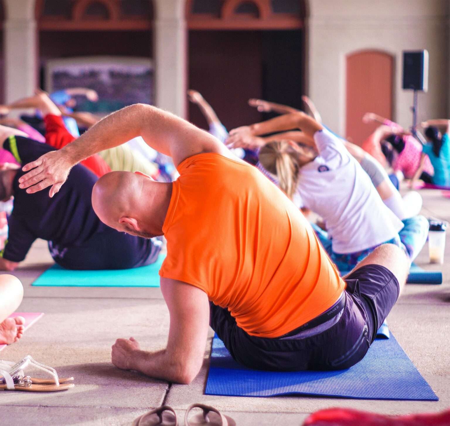 Salariés sur des tapis pendant une séance collective d’étirements avec un coach