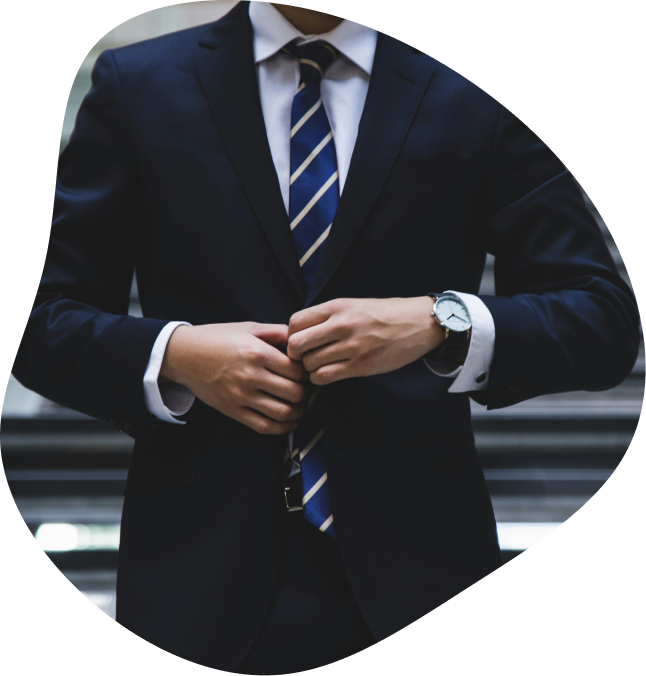 Un homme en costume cravate portant une montre et se tenant droit.