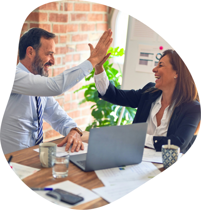 Un homme et une femme v&ecirc;tue de mani&egrave;re corporate autour d'une table de r&eacute;union. Il semble heureux et se font un 