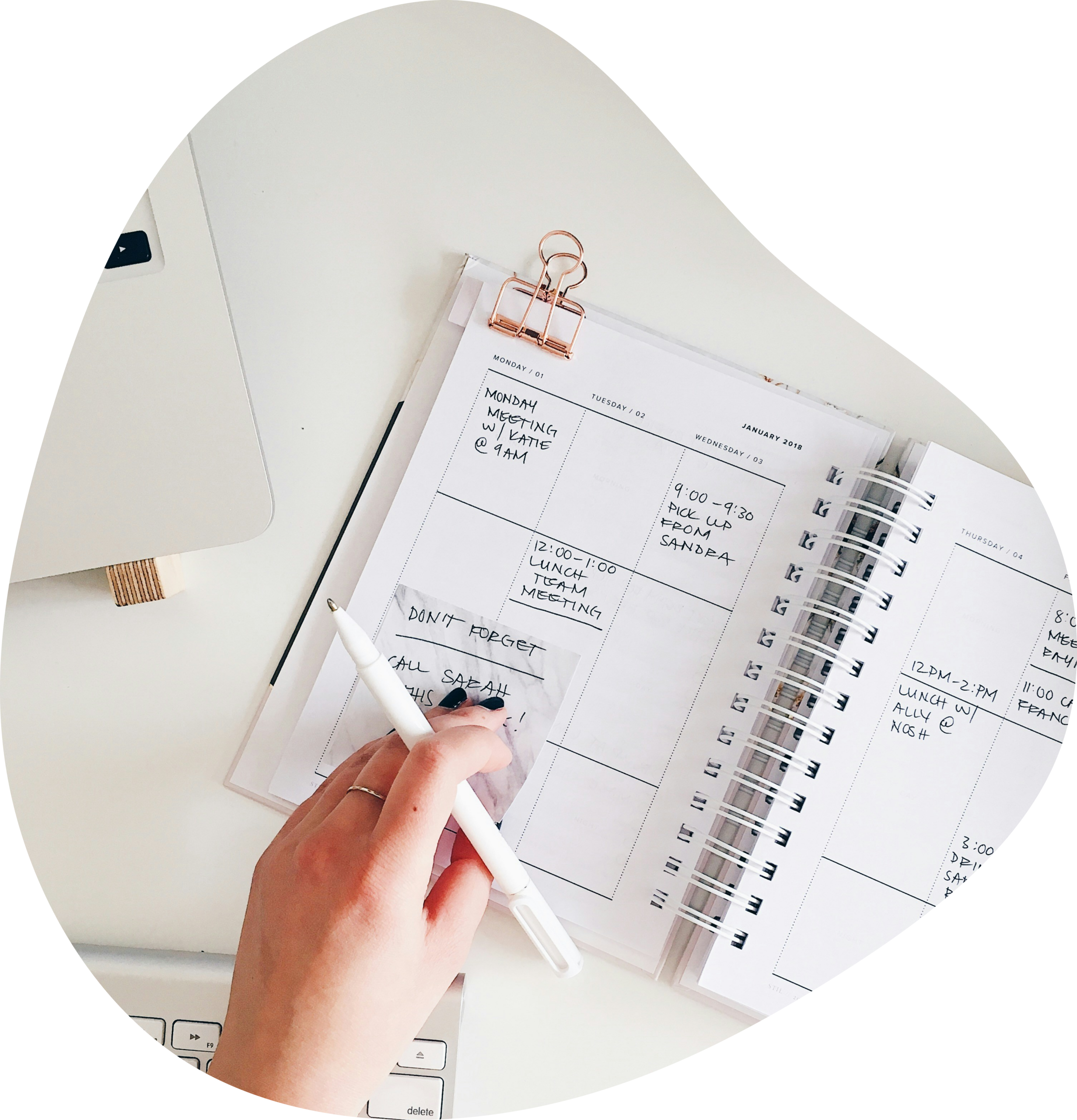 Vue zenithal d'une main qui rempli des cases de son calendrier fait &agrave; la main sur son carnet.