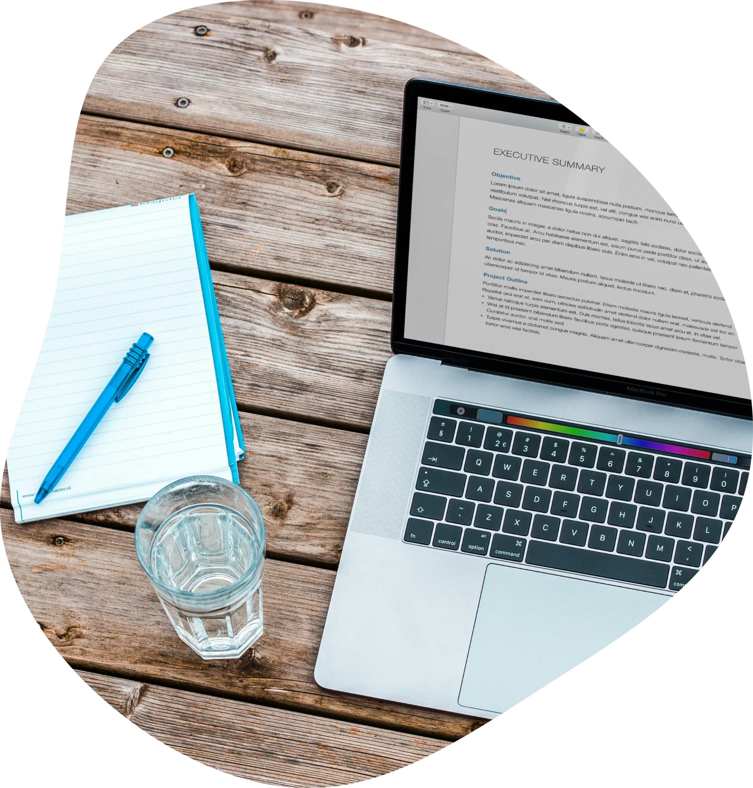 Vue zénithale sur un ordinateur portable, un verre d'eat et un carnet bleu