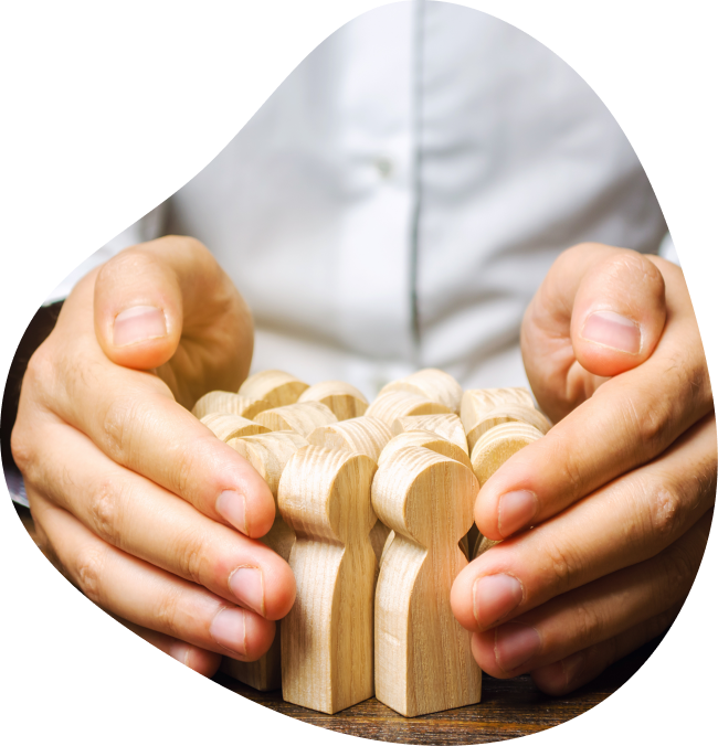 Un RH en chemise protégeant des petits pions en bois en forme d'humain