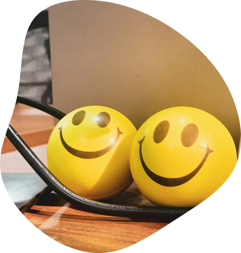 Gros plan sur 2 boules jaune avec une tête de smiley heureux imprimé dessus