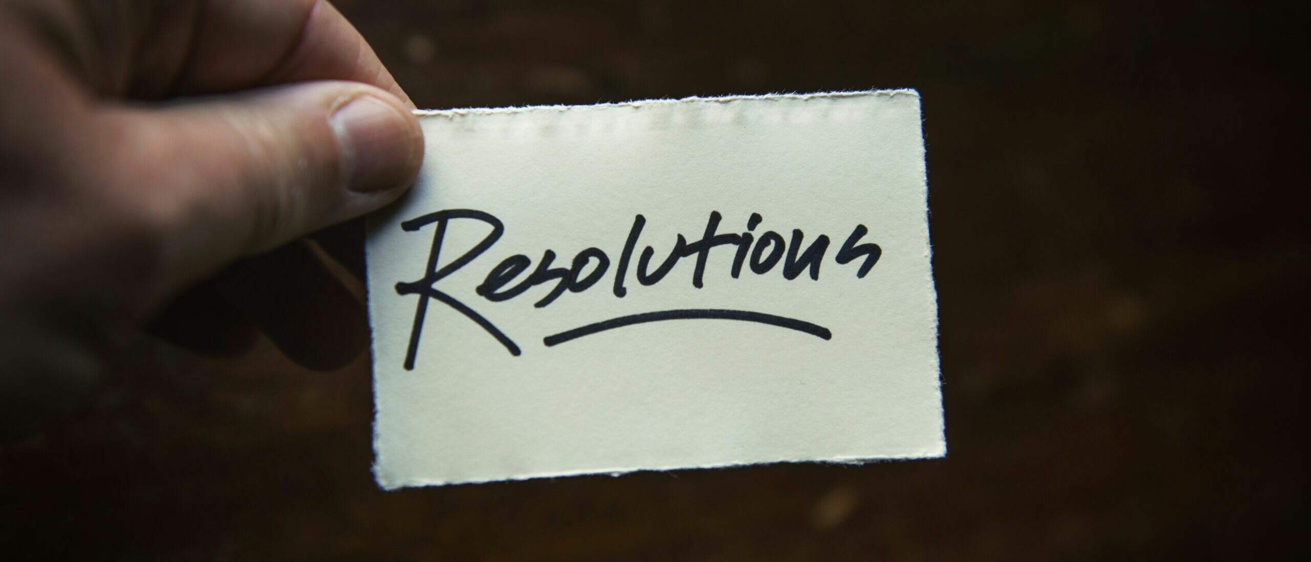 une main qui tient un petit papier avec marqué dessus 